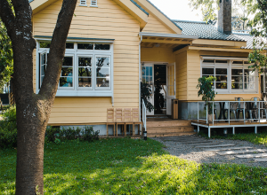 charming-yellow-house-with-wooden-windows-green-grassy-garden (1)